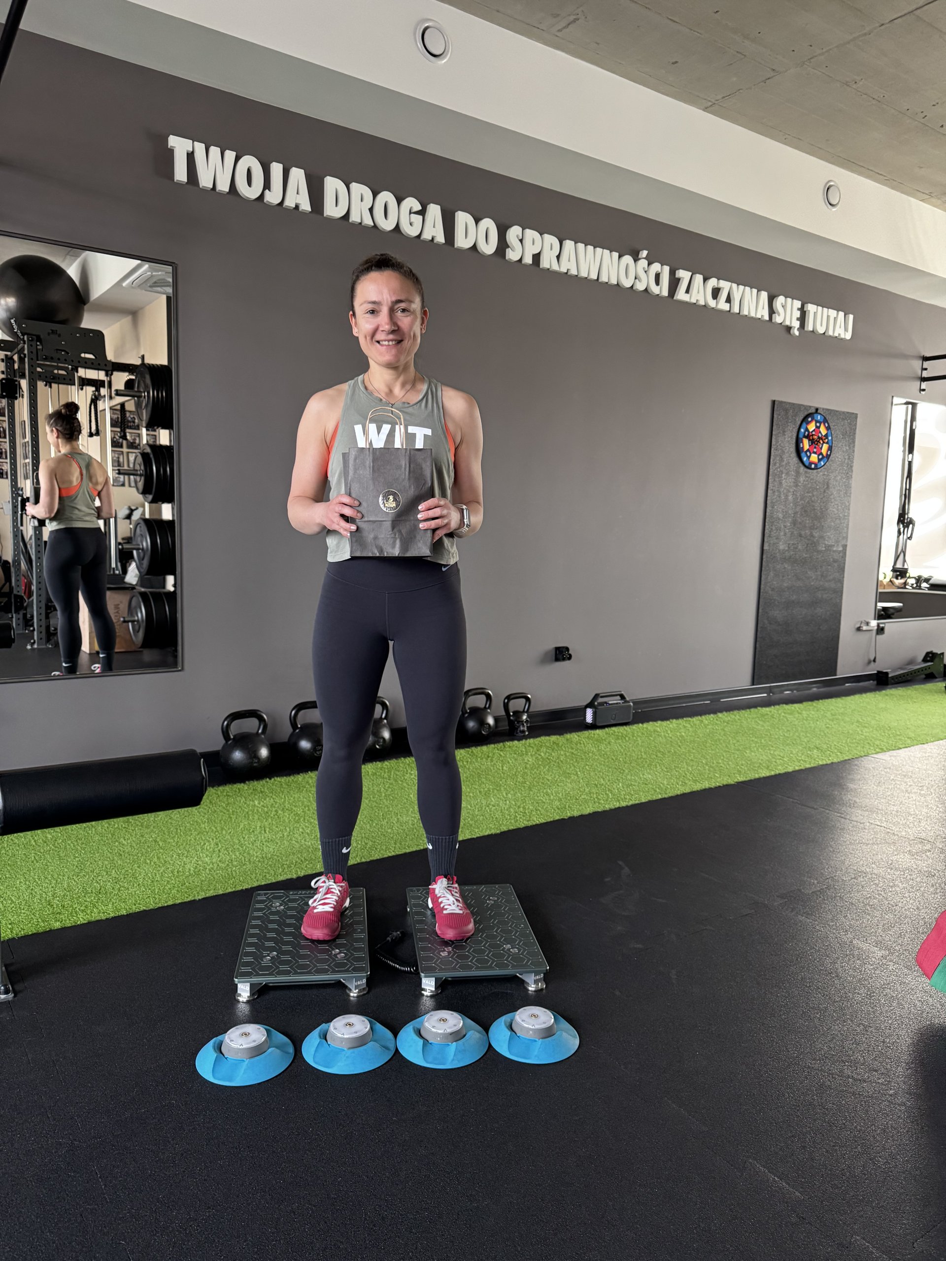 Trening z hantlami na nawierzchni sportowej w Movement Matters